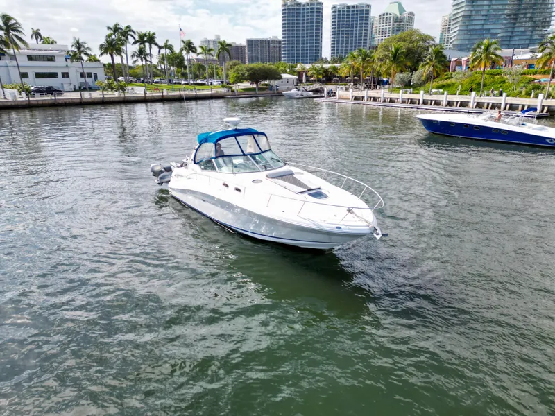 Slide: The Image of 2005 Sea Ray 340 Sundancer yacht cruising in a scenic marina with palm trees and buildings. - 42