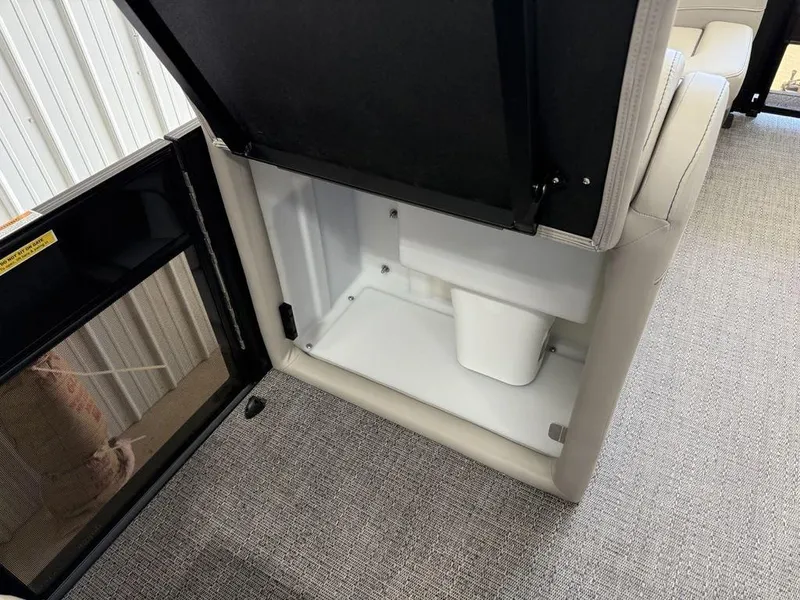 Slide: The Image of 2025 Barletta C22M storage compartment with open lid, showcasing interior space and carpeted flooring. - 10