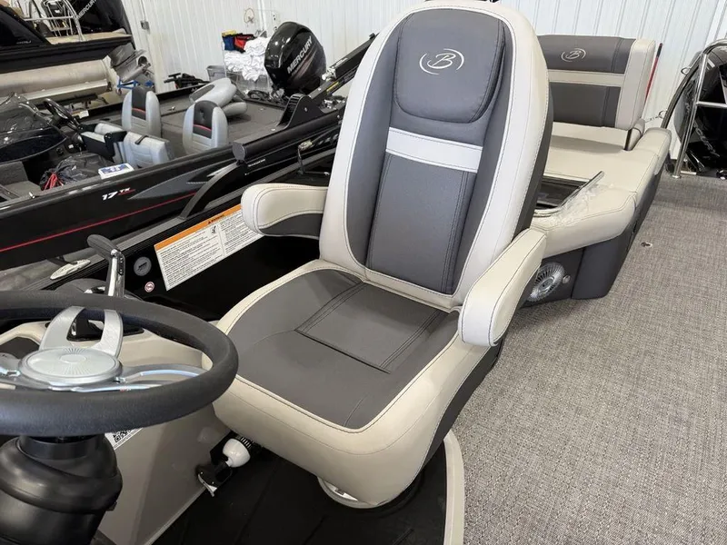 Slide: The Image of 2025 Barletta C22M boat interior with gray captain's chair and steering wheel. - 15