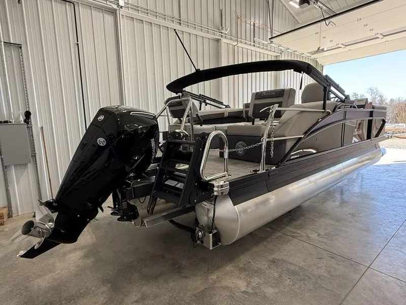 Slide: The Image of 2025 Barletta C22M pontoon boat in a garage, featuring a sleek design and powerful outboard motor. - 3