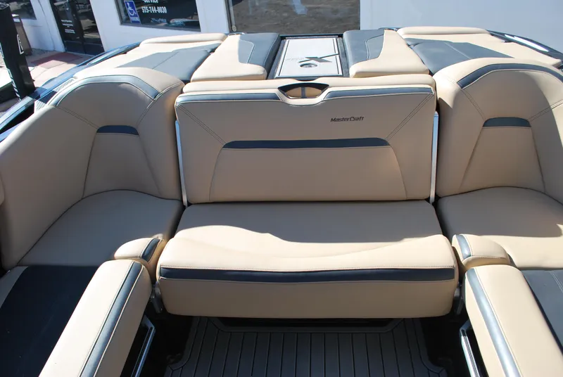 Slide: The Image of 2022 MasterCraft XStar boat interior with beige and black seating. - 12
