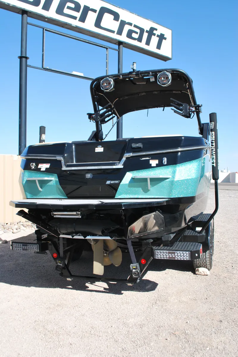 Slide: The Image of 2022 MasterCraft XStar boat on trailer, rear view, under clear blue sky. - 17