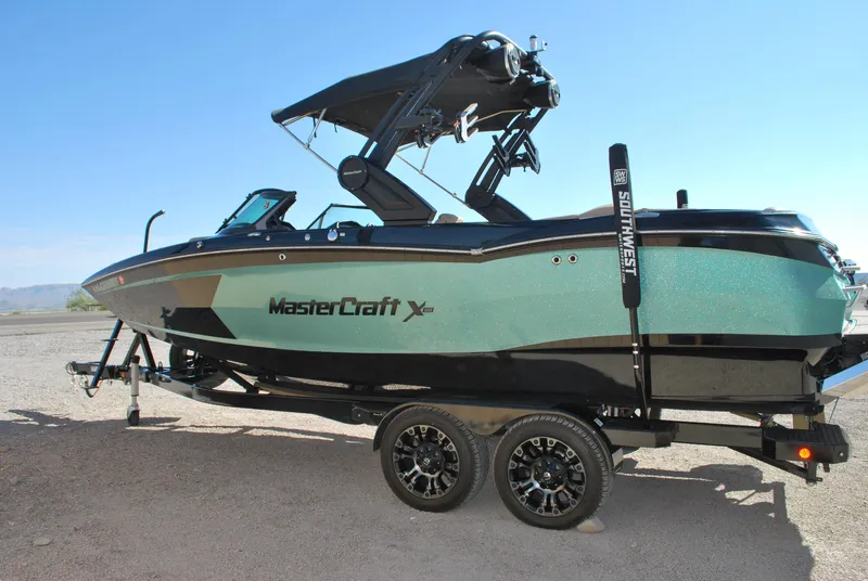 Slide: The Image of 2022 MasterCraft XStar boat on trailer, side view, outdoors. - 2