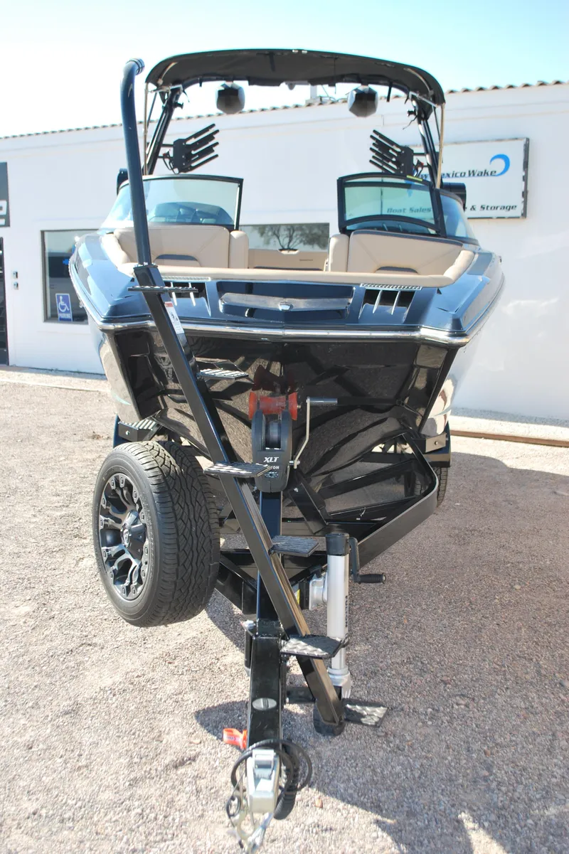 Slide: The Image of 2022 MasterCraft XStar boat on trailer, front view, parked outdoors. - 3