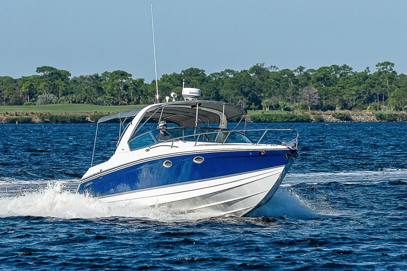 Slide: The Image of 2003 Formula 330 SS Super Sport boat cruising on a lake. - 10