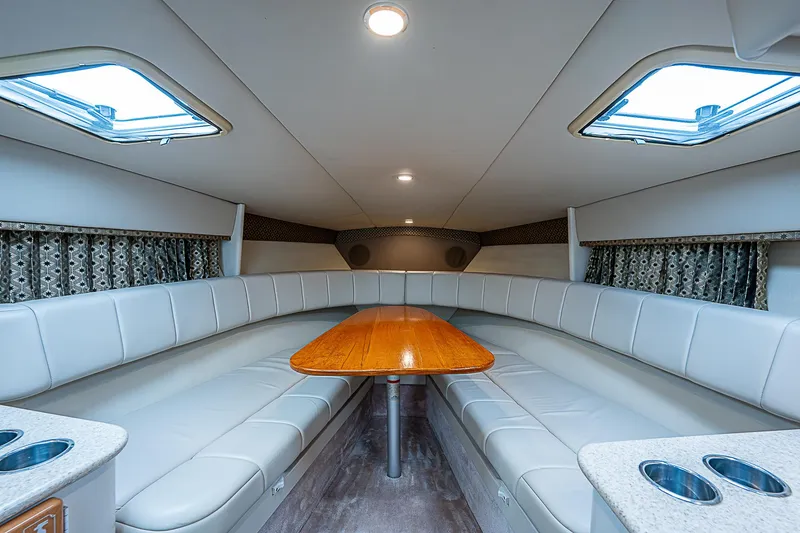 Slide: The Image of Luxurious interior of 2003 Formula 330 SS Super Sport boat with plush seating and wooden table. - 15