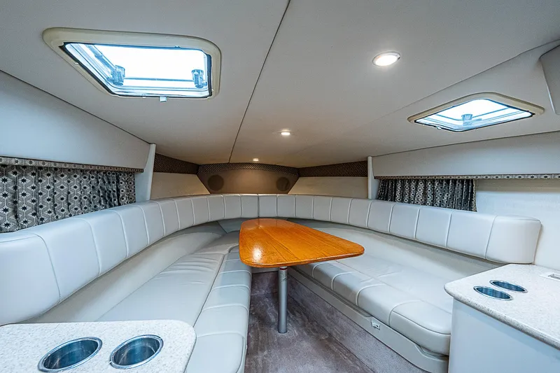 Slide: The Image of 2003 Formula 330 SS Super Sport cabin with plush seating and wooden table. - 16