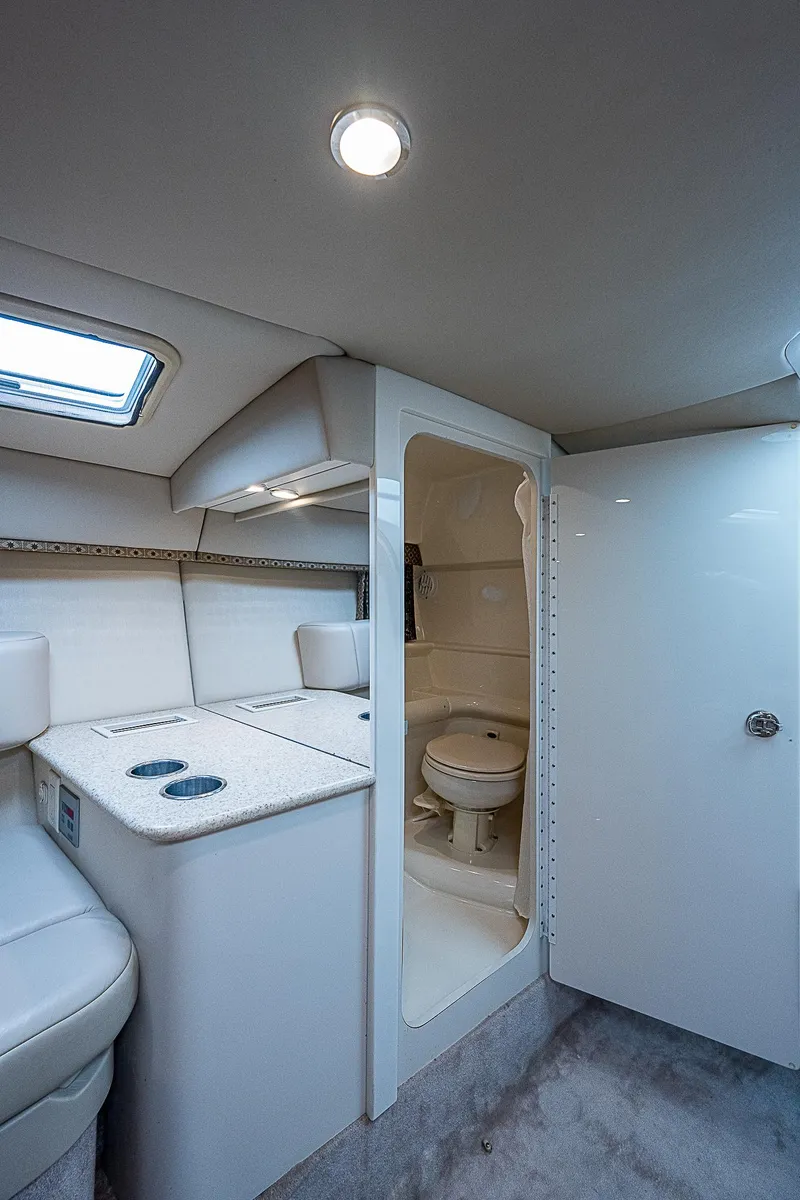 Slide: The Image of Interior of 2003 Formula 330 SS Super Sport boat with bathroom and seating area. - 19