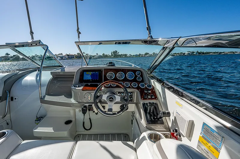 Slide: The Image of 2003 Formula 330 SS Super Sport boat cockpit with steering wheel and dashboard on open water. - 23