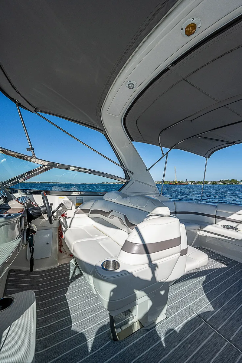 Slide: The Image of 2003 Formula 330 SS Super Sport boat interior with seating and canopy on open water. - 25