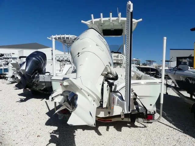 Slide: The Image of 2021 Avenger Boats AV24 with powerful outboard motor, displayed in a sunny boatyard. - 5