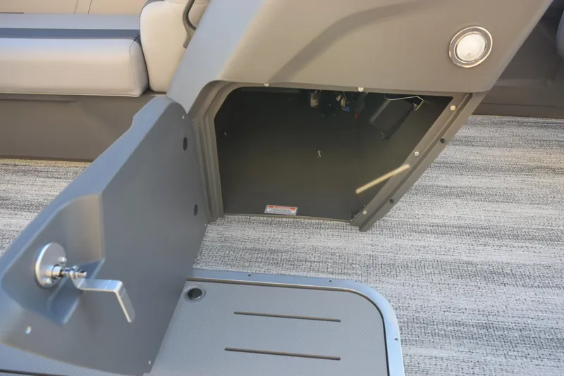 Slide: The Image of 2025 Bennington 23 SSBSE boat storage compartment with open door and latch. - 15