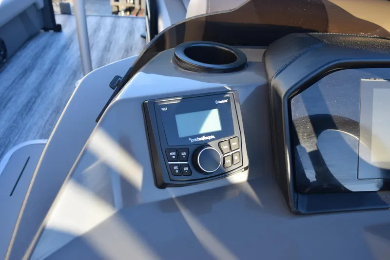 Slide: The Image of 2025 Bennington 23 SSBSE boat dashboard with audio controls and cup holder. - 19
