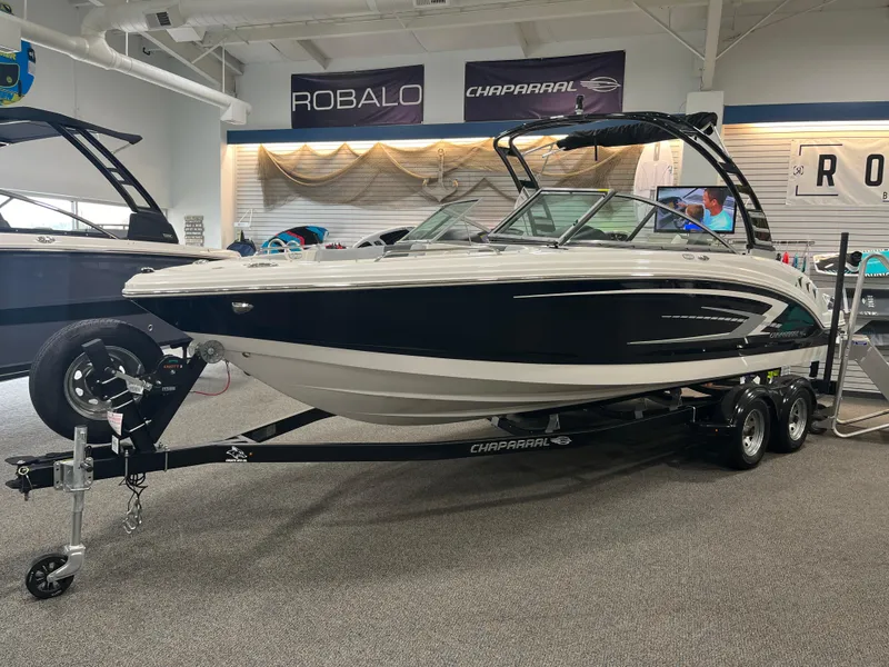 Slide: The Image of 2025 Chaparral 23 SSi boat on trailer in showroom, featuring sleek design and modern features. - 1