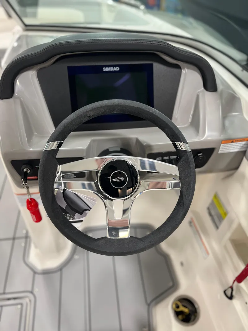 Slide: The Image of 2025 Chaparral 23 SSi boat dashboard with steering wheel and Simrad display. - 15