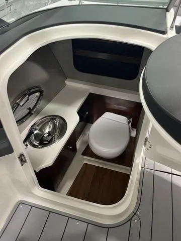 Slide: The Image of 2025 Chaparral 30 Surf boat in showroom, side view. - 13