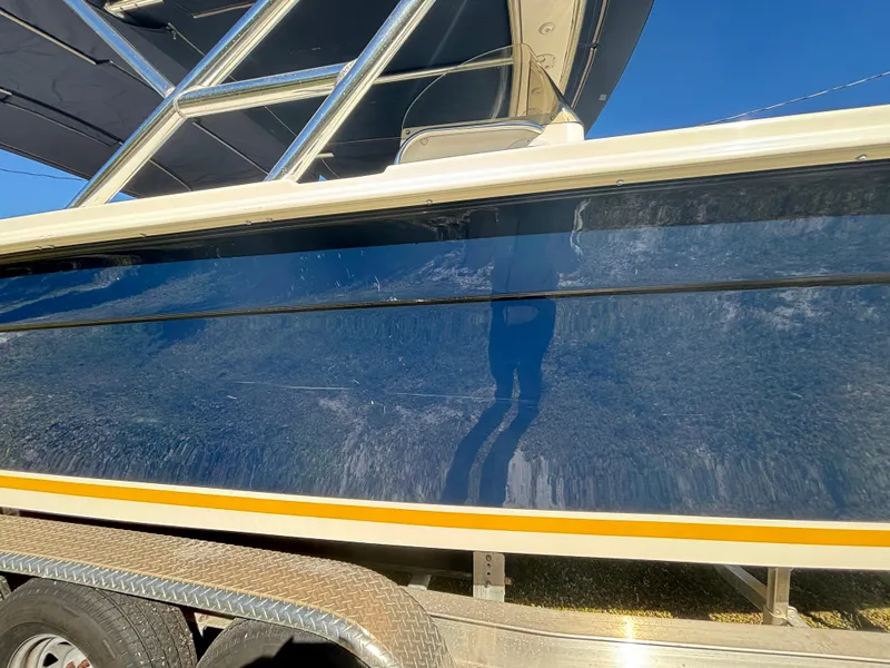 Slide: The Image of 2002 Marlago 35 FS boat side view on trailer, blue hull with yellow stripe. - 11