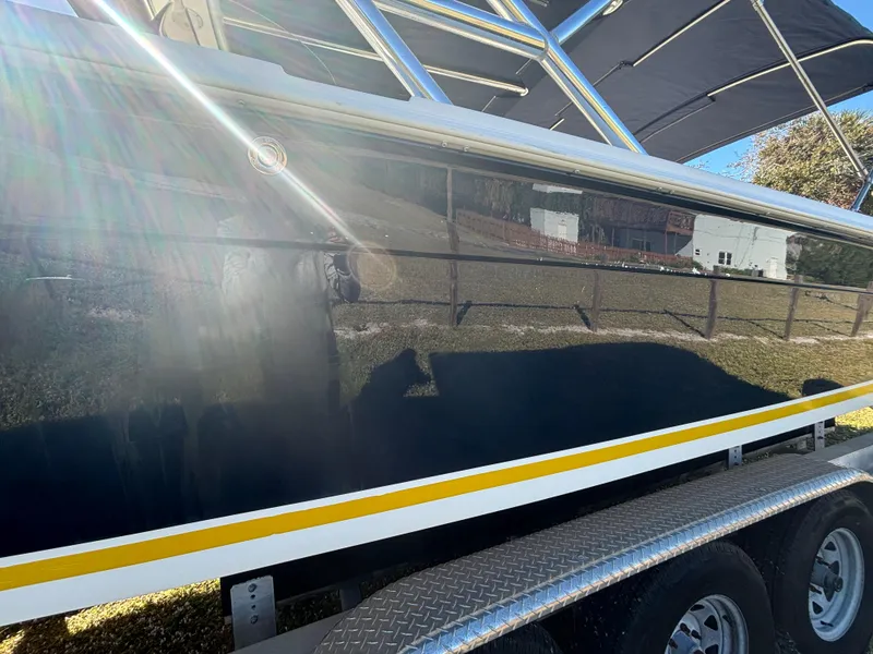 Slide: The Image of 2002 Marlago 35 FS boat on trailer, reflecting sunlight and surroundings. - 13