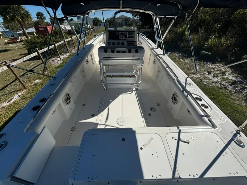 Slide: The Image of 2002 Marlago 35 FS boat interior with console and seating, docked outdoors. - 16