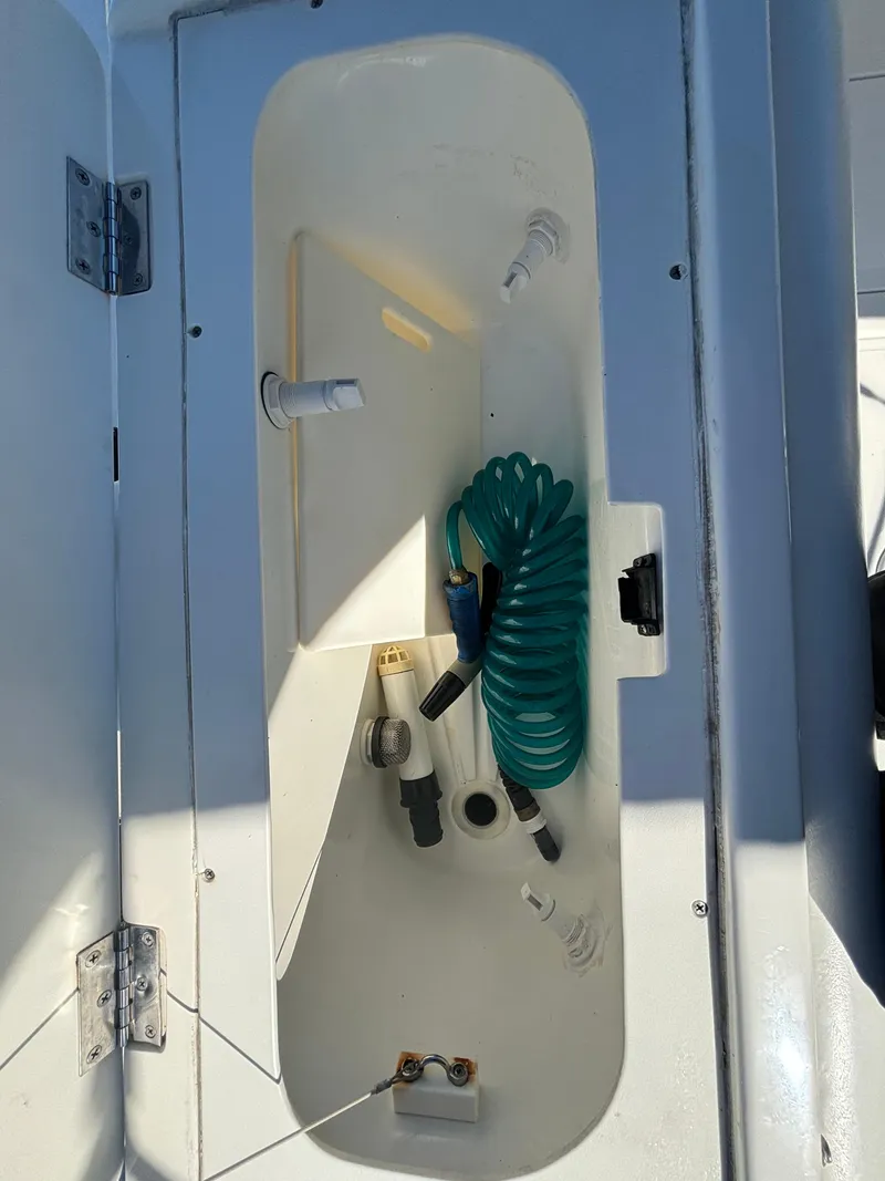 Slide: The Image of Open storage compartment on a 2002 Marlago 35 FS boat with coiled hose. - 39