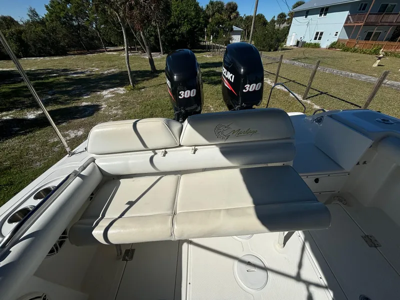 Slide: The Image of 2002 Marlago 35 FS boat with dual Suzuki 300 engines, beige seating, outdoor setting. - 47