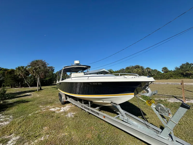 Slide: The Image of 2002 Marlago 35 FS boat on trailer under clear blue sky. - 5