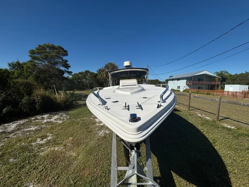 Slide: The Image of 2002 Marlago 35 FS boat on trailer, parked on grassy area under clear blue sky. - 6