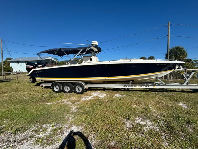 Slide: The Image of 2002 Marlago 35 FS boat on trailer, parked on grass under clear blue sky. - 8