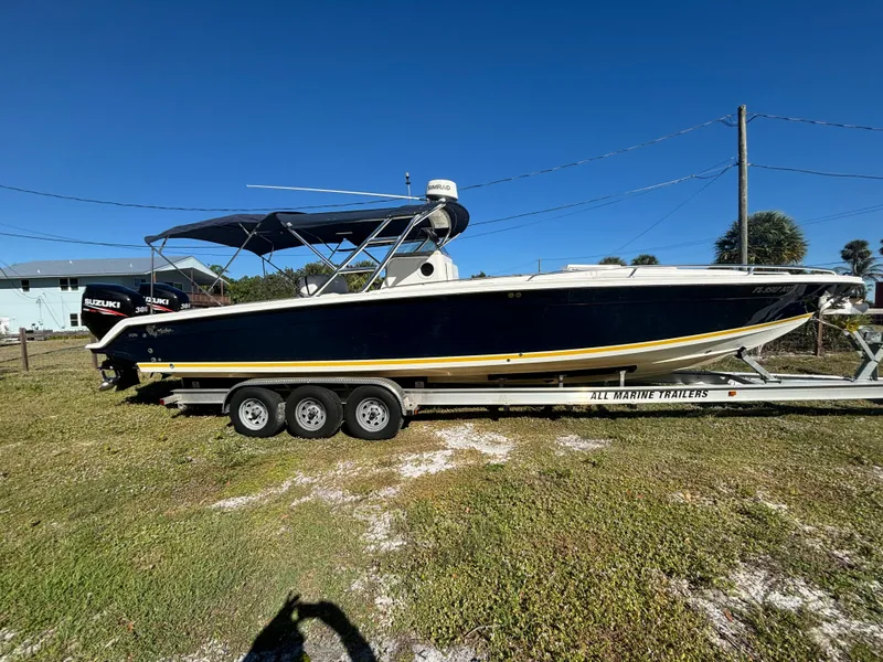 Slide: The Image of 2002 Marlago 35 FS boat on trailer, parked on grass under clear blue sky. - 9