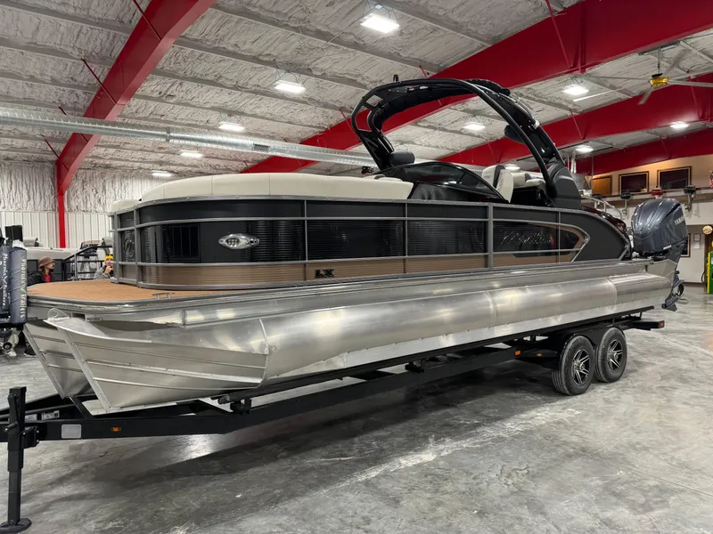 The Image of 2023 Manitou 25 LX Twin SHP pontoon boat in a showroom. - 1