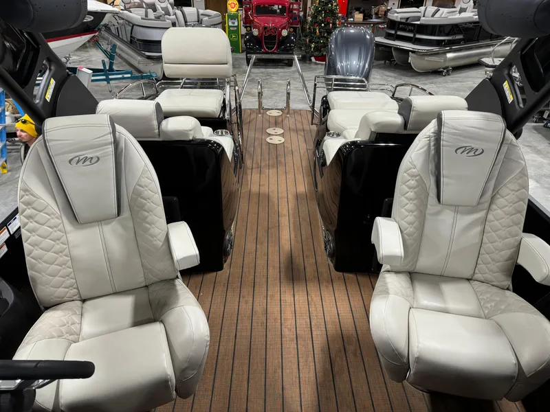 Slide: The Image of 2023 Manitou 25 LX Twin SHP boat interior with luxurious seating and wood flooring. - 10