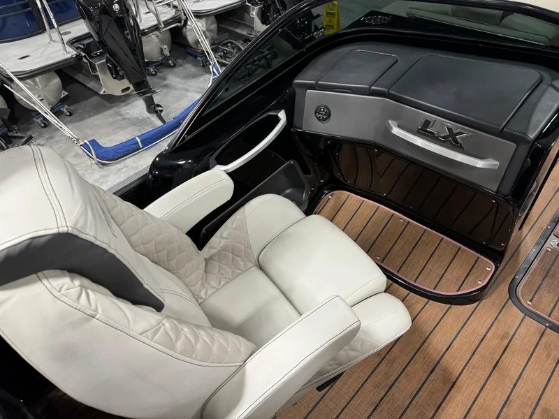 Slide: The Image of 2023 Manitou 25 LX Twin SHP boat interior with luxury seating and sleek dashboard. - 11