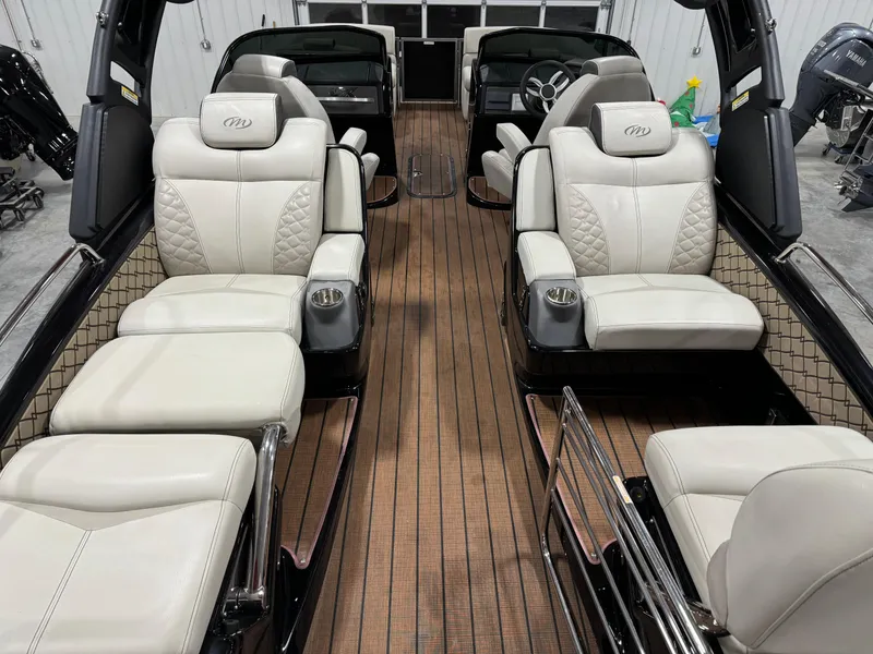 Slide: The Image of 2023 Manitou 25 LX Twin SHP boat interior with luxurious seating and wood flooring. - 13
