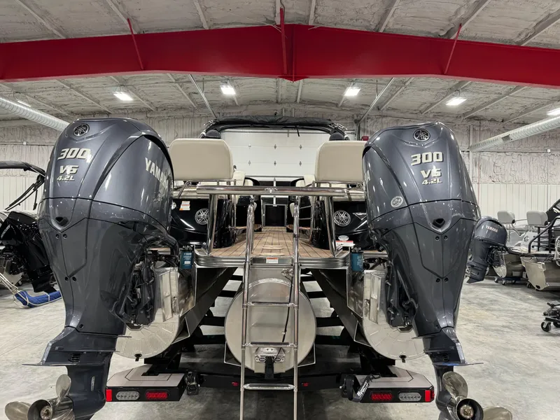 Slide: The Image of 2023 Manitou 25 LX Twin SHP with dual Yamaha 300 V6 engines in a warehouse. - 6