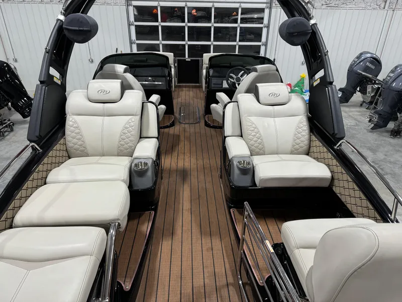 Slide: The Image of 2023 Manitou 25 LX Twin SHP boat interior with luxurious seating and wood flooring. - 7