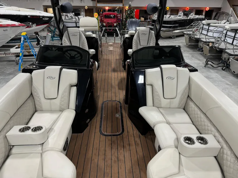 Slide: The Image of 2023 Manitou 25 LX Twin SHP luxury boat interior with plush seating and wood flooring. - 8