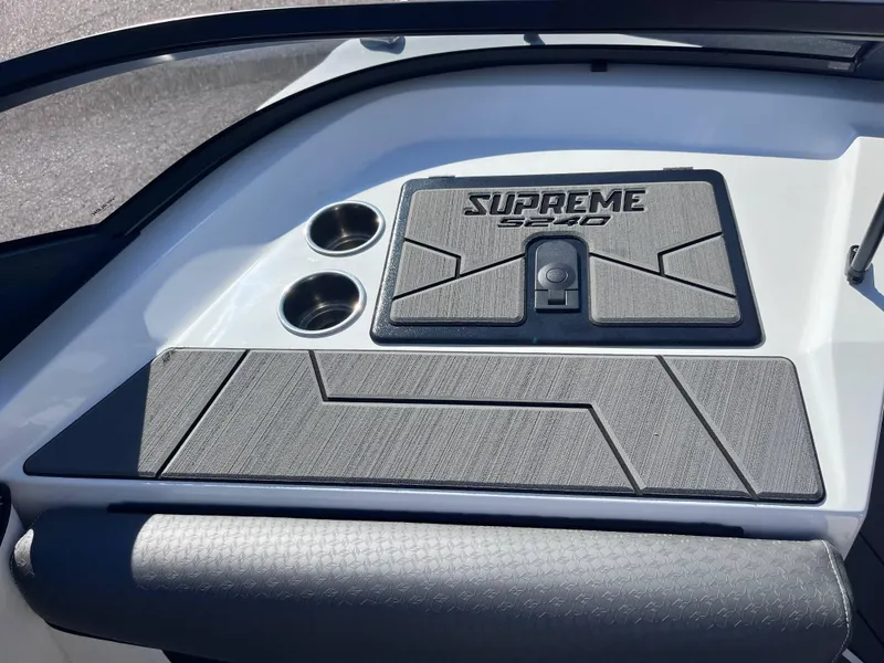Slide: The Image of 2025 Supreme S240 boat interior with cup holders and textured panel. - 10