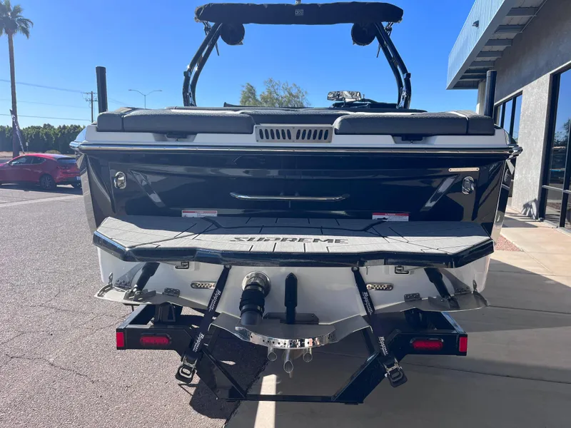 Slide: The Image of 2025 Supreme S240 boat rear view in parking lot, showcasing sleek design and features. - 3