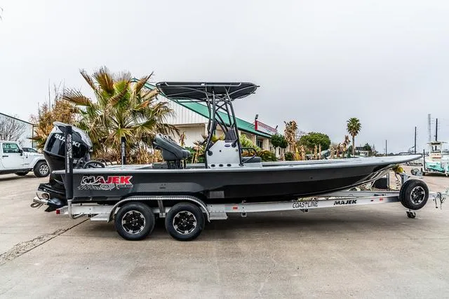 Slide: The Image of 2024 Majek Boats 25 XTREME on trailer, parked outdoors with palm trees in background. - 1