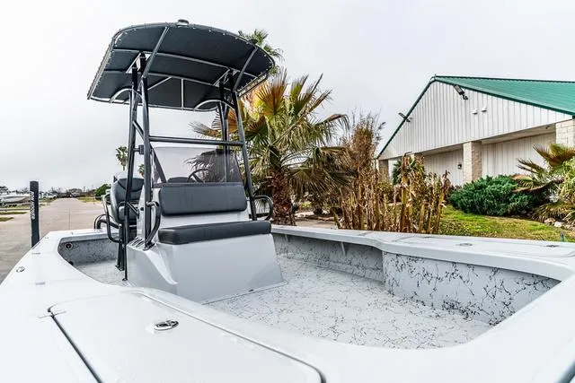 Slide: The Image of 2024 Majek Boats 25 XTREME with T-top, docked near palm trees and a building. - 11