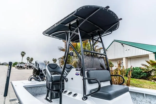 Slide: The Image of 2024 Majek Boats 25 XTREME with T-top and seating, parked outdoors near palm trees. - 12