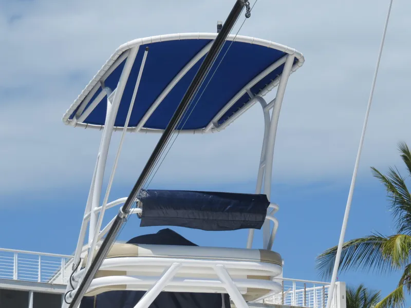Slide: The Image of 2015 Invincible 42 Open Fisherman boat with blue canopy against a cloudy sky. - 47