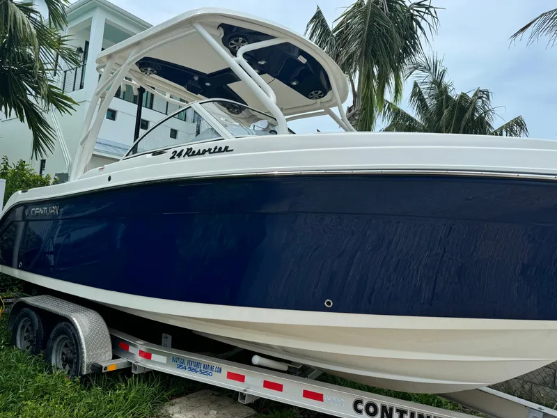 Slide: The Image of 2016 Century 24 Resorter boat on trailer, parked near palm trees. - 0