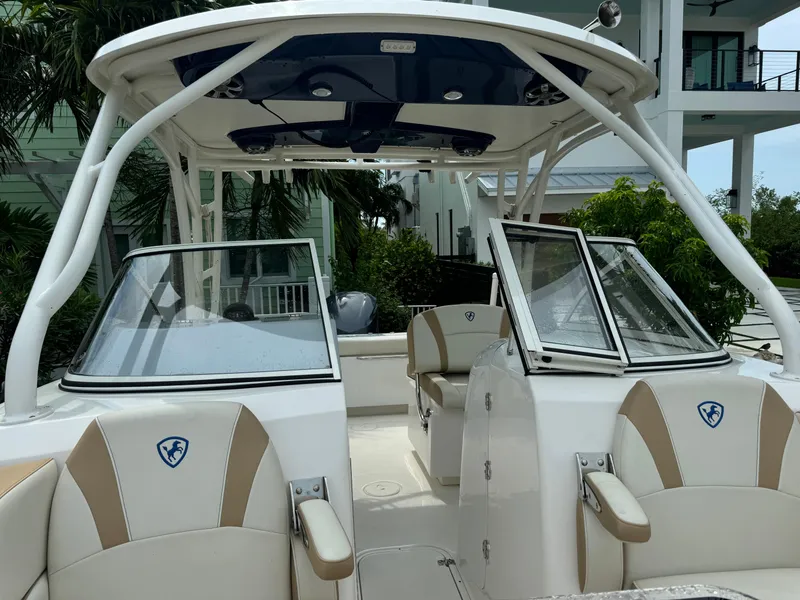 Slide: The Image of 2016 Century 24 Resorter boat with dual consoles and seating, docked near modern buildings. - 11