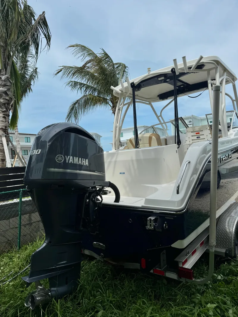 Slide: The Image of 2016 Century 24 Resorter boat with Yamaha engine, parked on grass near palm trees. - 3