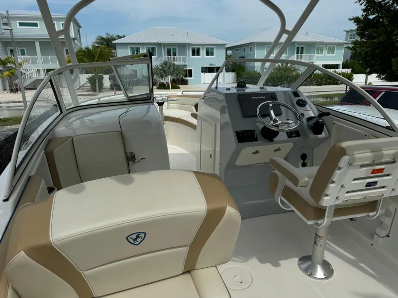 Slide: The Image of 2016 Century 24 Resorter boat interior with helm, seating, and modern dashboard. - 7