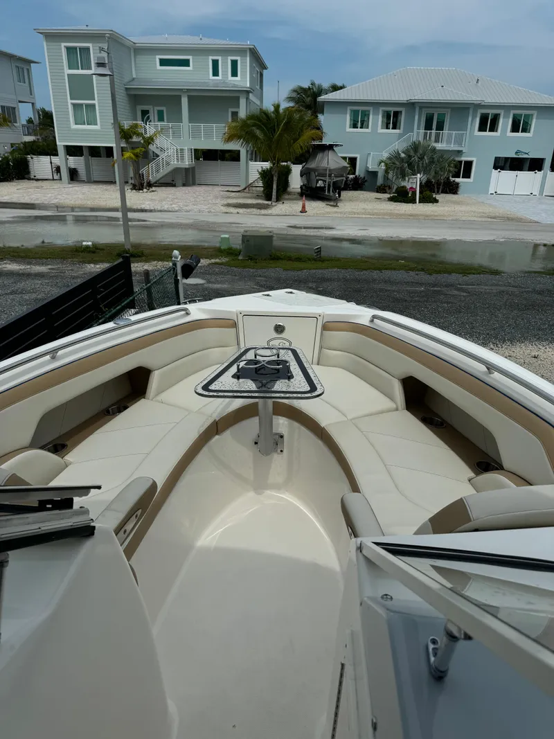 Slide: The Image of 2016 Century 24 Resorter boat with spacious seating, docked near modern waterfront homes. - 8