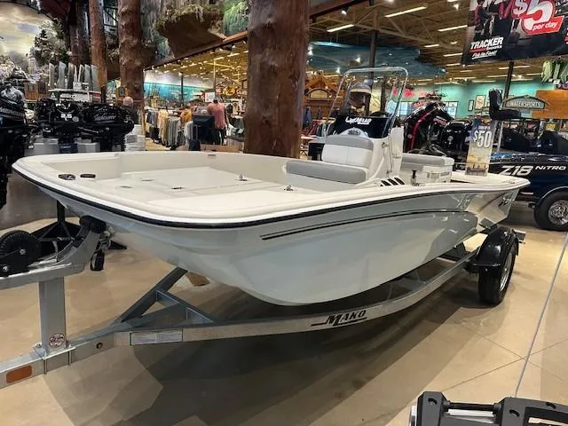 Slide: The Image of 2025 Mako Pro Skiff 15 CC boat displayed indoors on a trailer. - 0