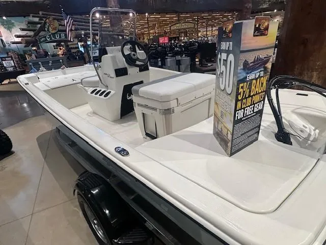 Slide: The Image of 2025 Mako Pro Skiff 15 CC boat displayed indoors with promotional signage. - 2