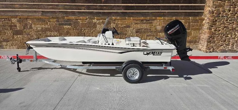 Slide: The Image of 2025 Mako Pro Skiff 15 CC boat on trailer, parked on concrete surface. - 0